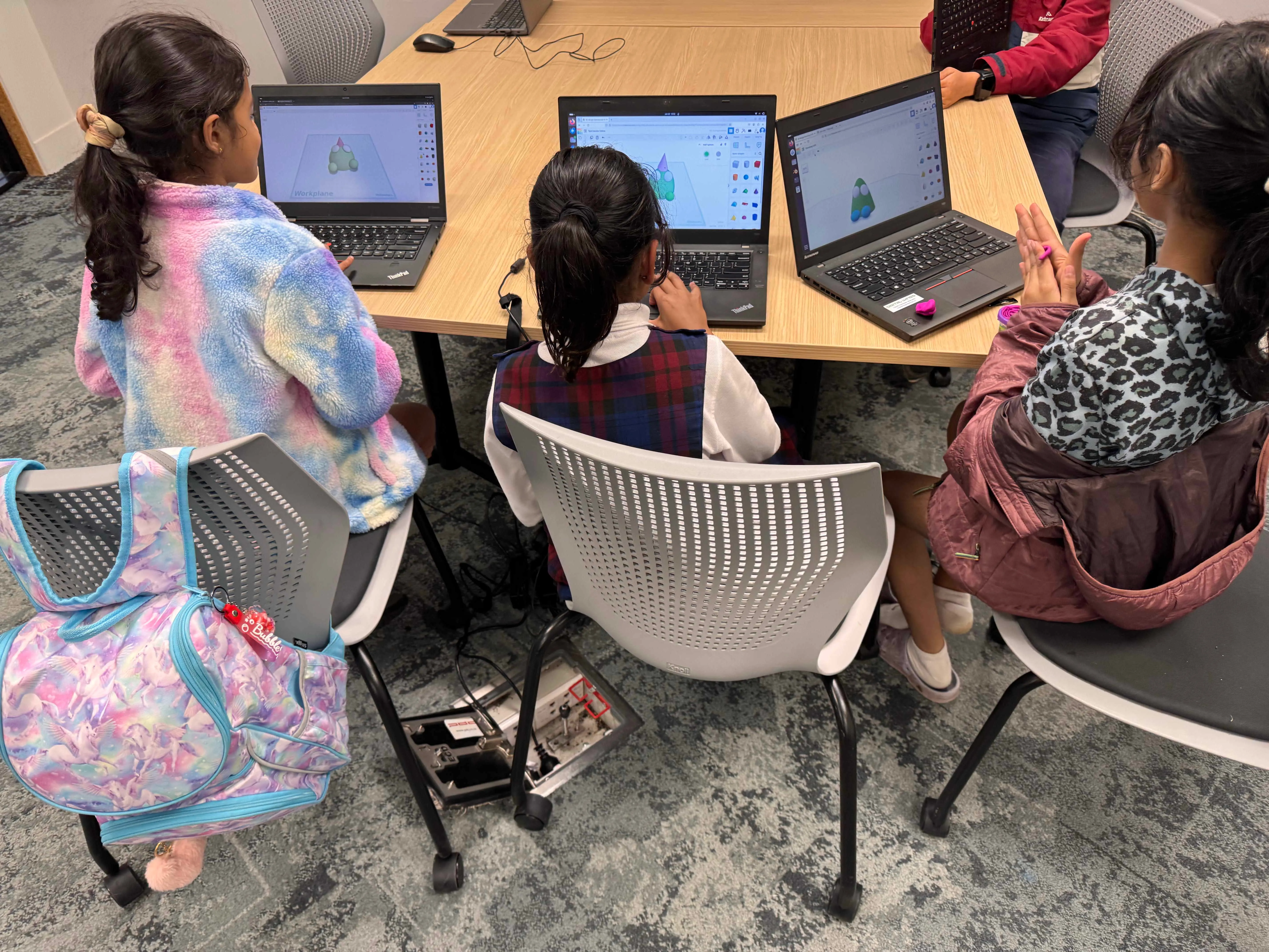 Rangatahi engaged in hands-on learning with computers and technology equipment